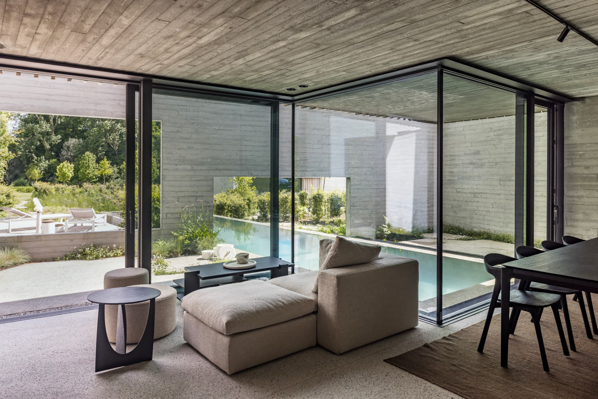 View through black-framed glazing from the living room to the infinity pool