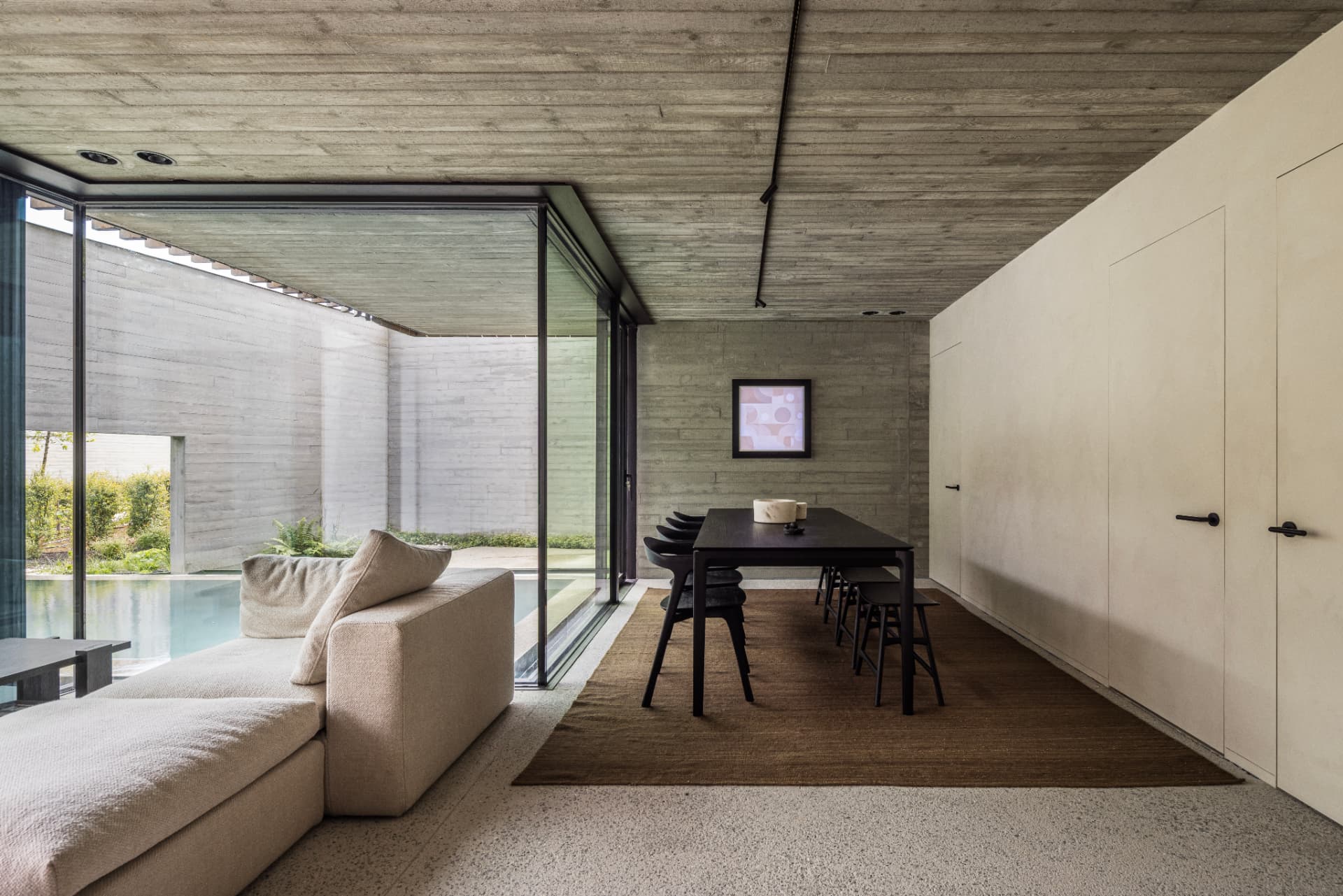 Light-filled living and dining space beside the pool at OXfield