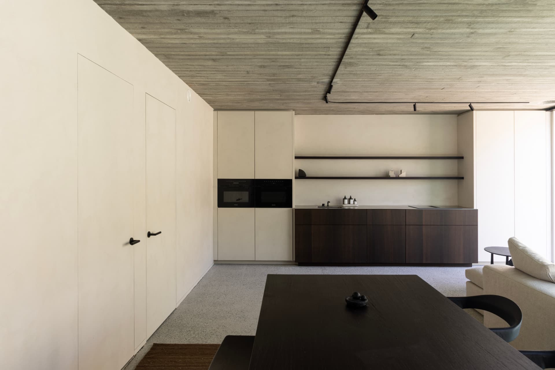 Open kitchen with pale cabinetry and dark island at OXfield