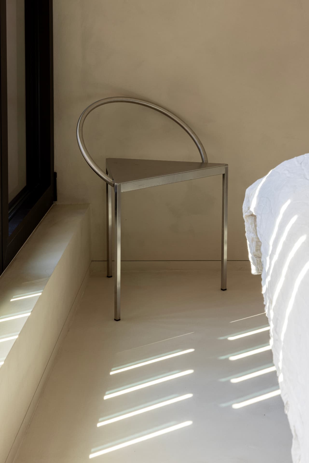 Chrome loop-back chair in a quiet corner of an OXfield bedroom