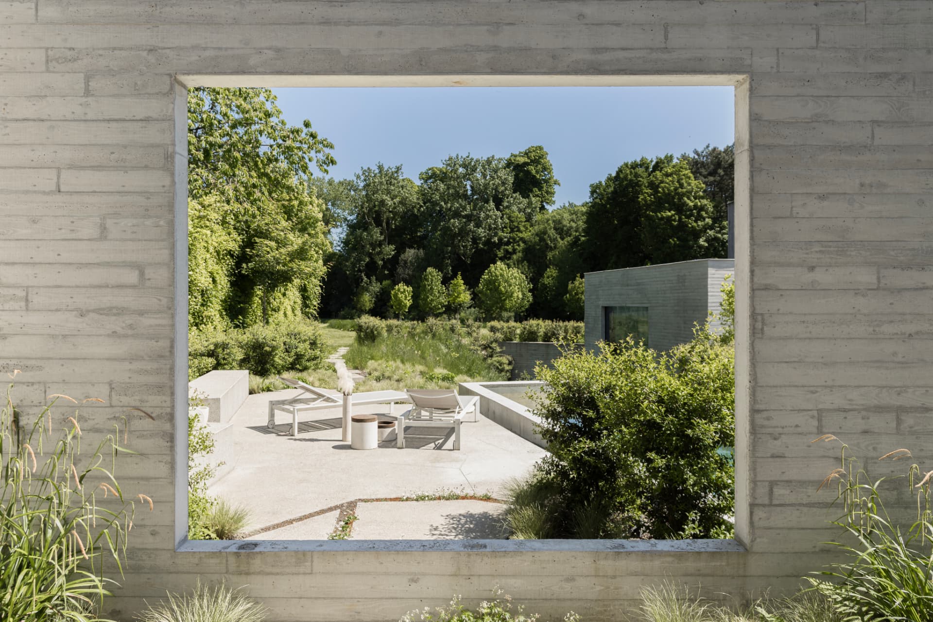 View along a concrete wall toward the garden terrace
